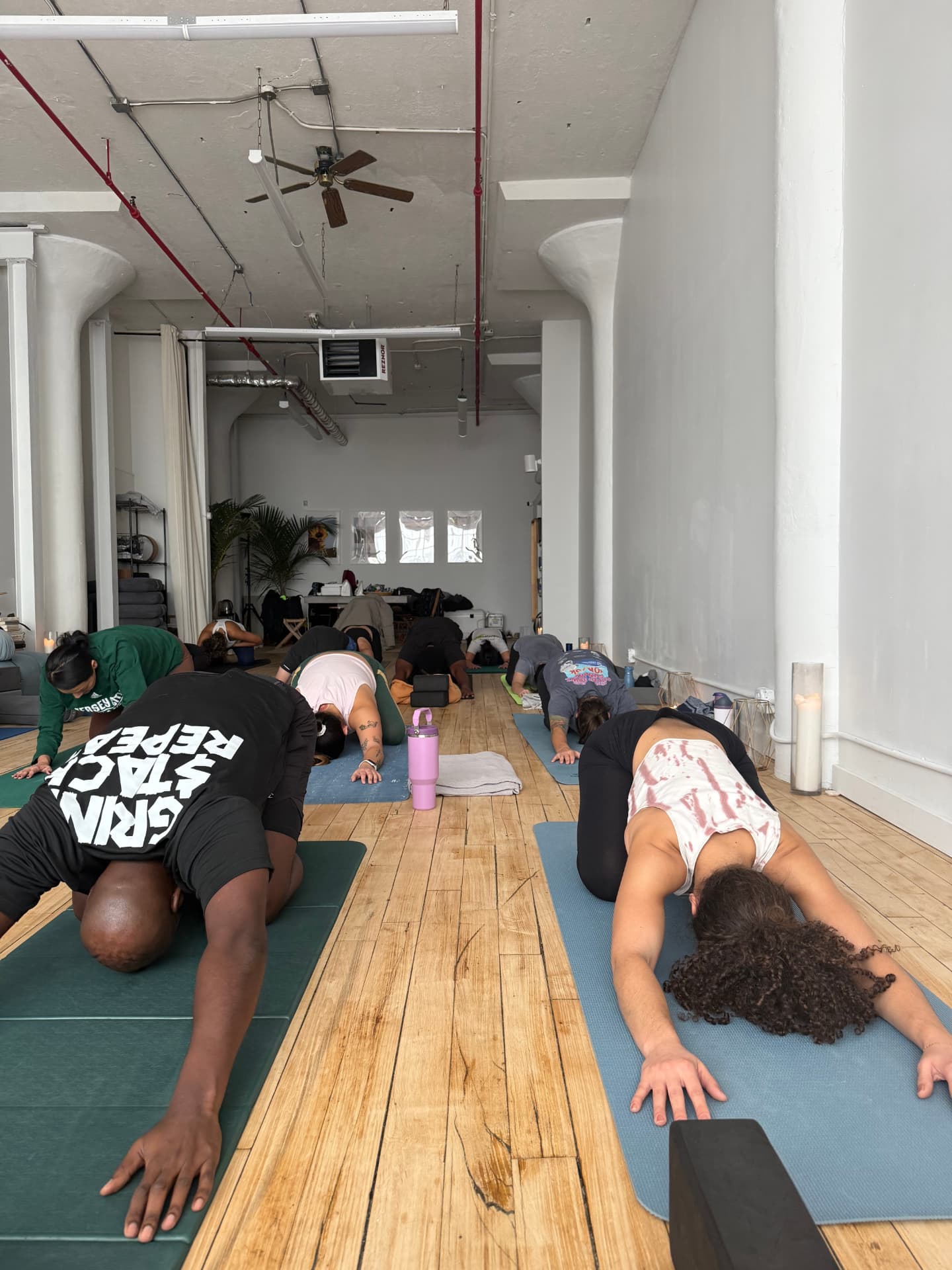 Members resting forward on their mats in child's pose