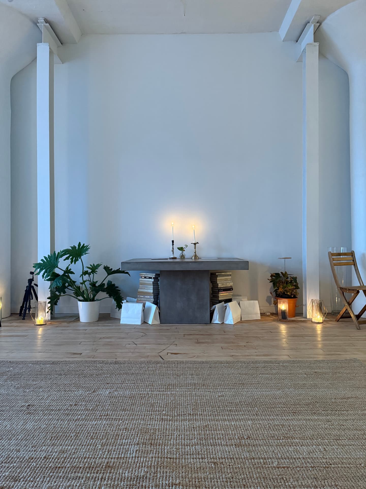 A candlelit table stacked with books, set for a seasonal gathering